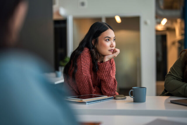 photo - Young Businesswoman Listening during Meeting with notebook and Devices
