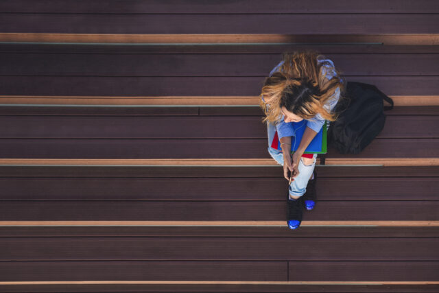 photo - Student Girl on Campus Is Sitting on the Stairs