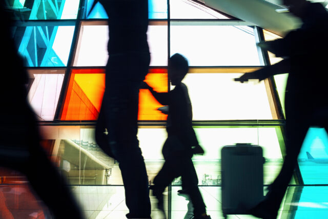 photo - Passengers Pushing Luggage Carts in Airport Terminal